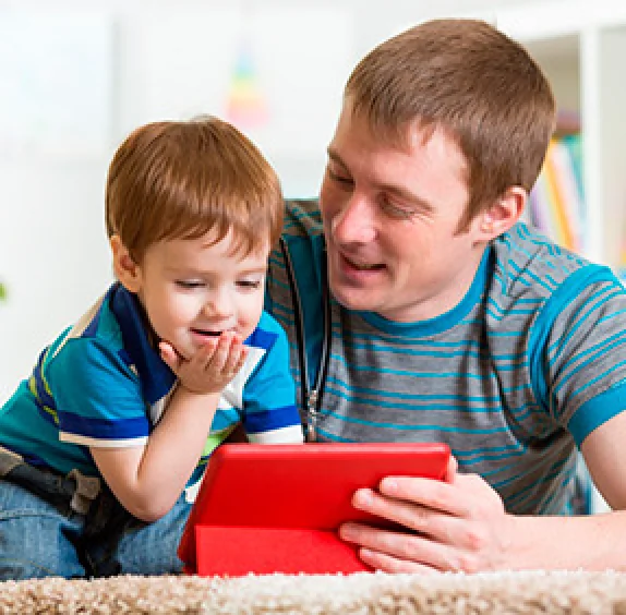 Niño con su papá viendo su tablet
